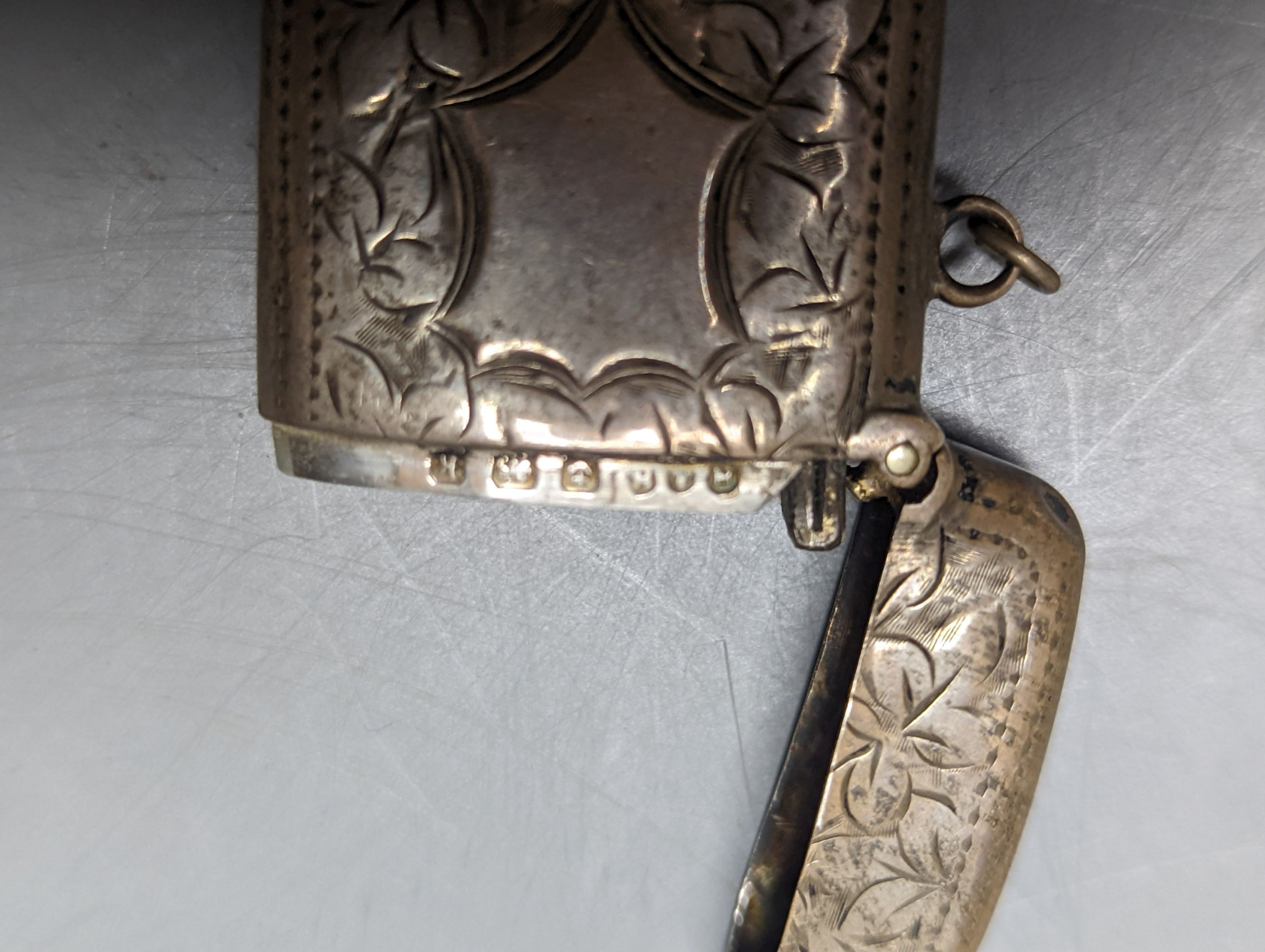 A George V silver cigarette case, an earlier silver vesta case and a cased set of button hooks, shoe horn and glove stretchers.